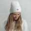 Vrouwelijk model met geborduurde gepersonaliseerde wintermuts met een voorbeeld van een logo-ontwerp
