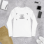Langärmeliges T-Shirt auf einem Hintergrund, umgeben von Gegenständen wie Telefon und Brieftasche 