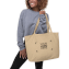 Female model carrying a personalized tote bag with a logo design around her arm